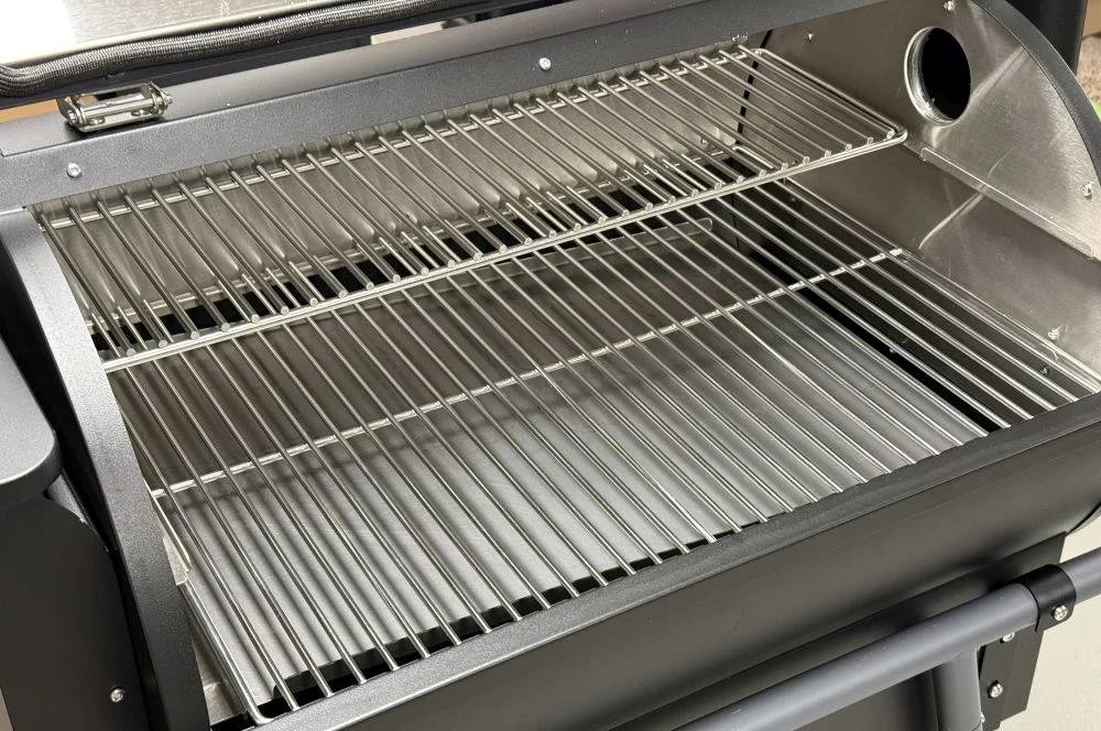 Intérieur du barbecue à pellets MOESTA Sheriff avec grilles en acier inoxydable sur deux niveaux pour cuisson directe et indirecte.